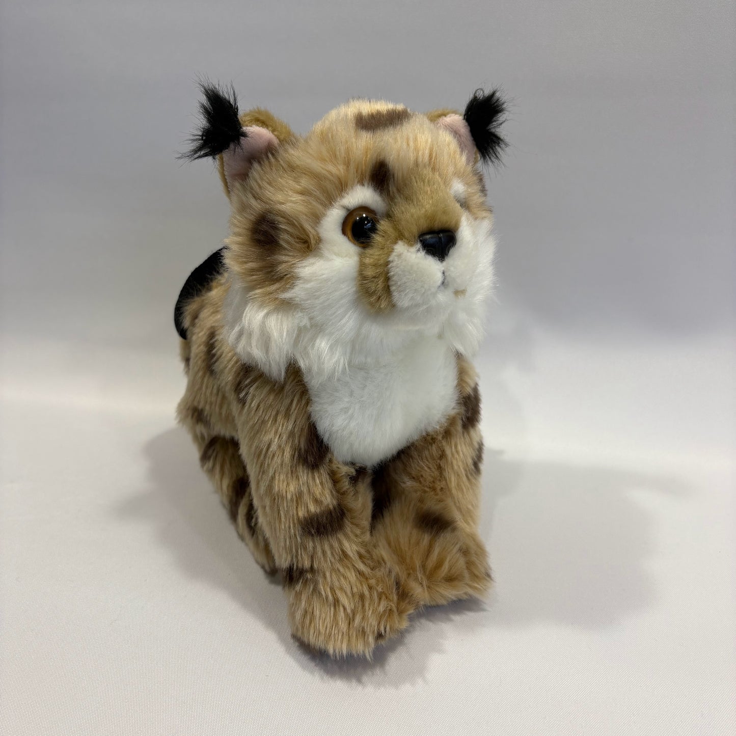 Bobcat plush rock climbing chalk bag shown in a sitting position, showing unique climbing gear for kids and women