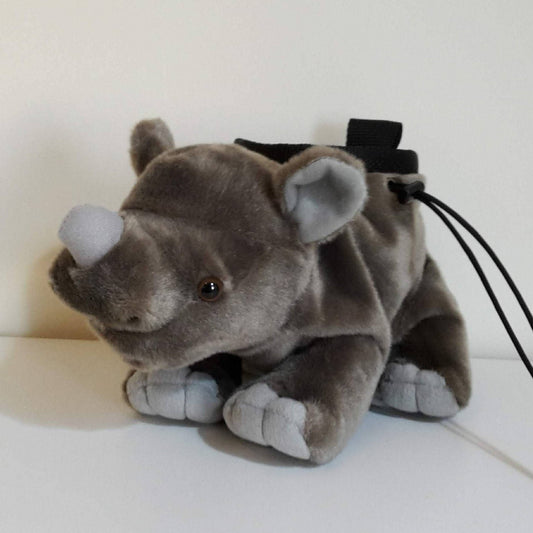 Plush rhino chalk bag made from a soft toy, with a grey body, light grey horn and feet, black drawstring closure, and a webbing loop at the top, designed for rock climbing or bouldering use.